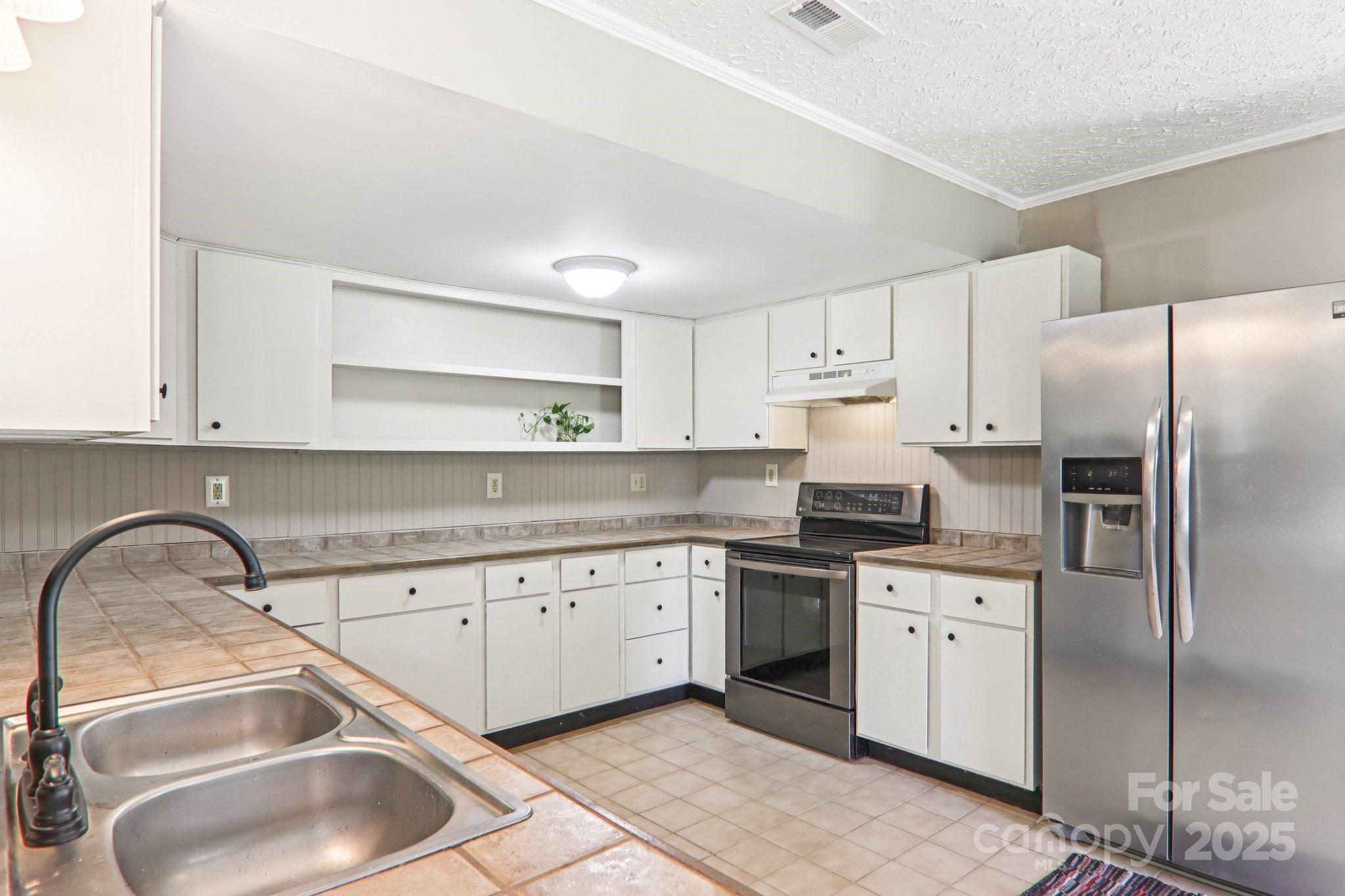 55 Polk Street Waynesville, NC 28786 - Photo 19 of 44 a kitchen with a sink cabinets and stainless steel appliances