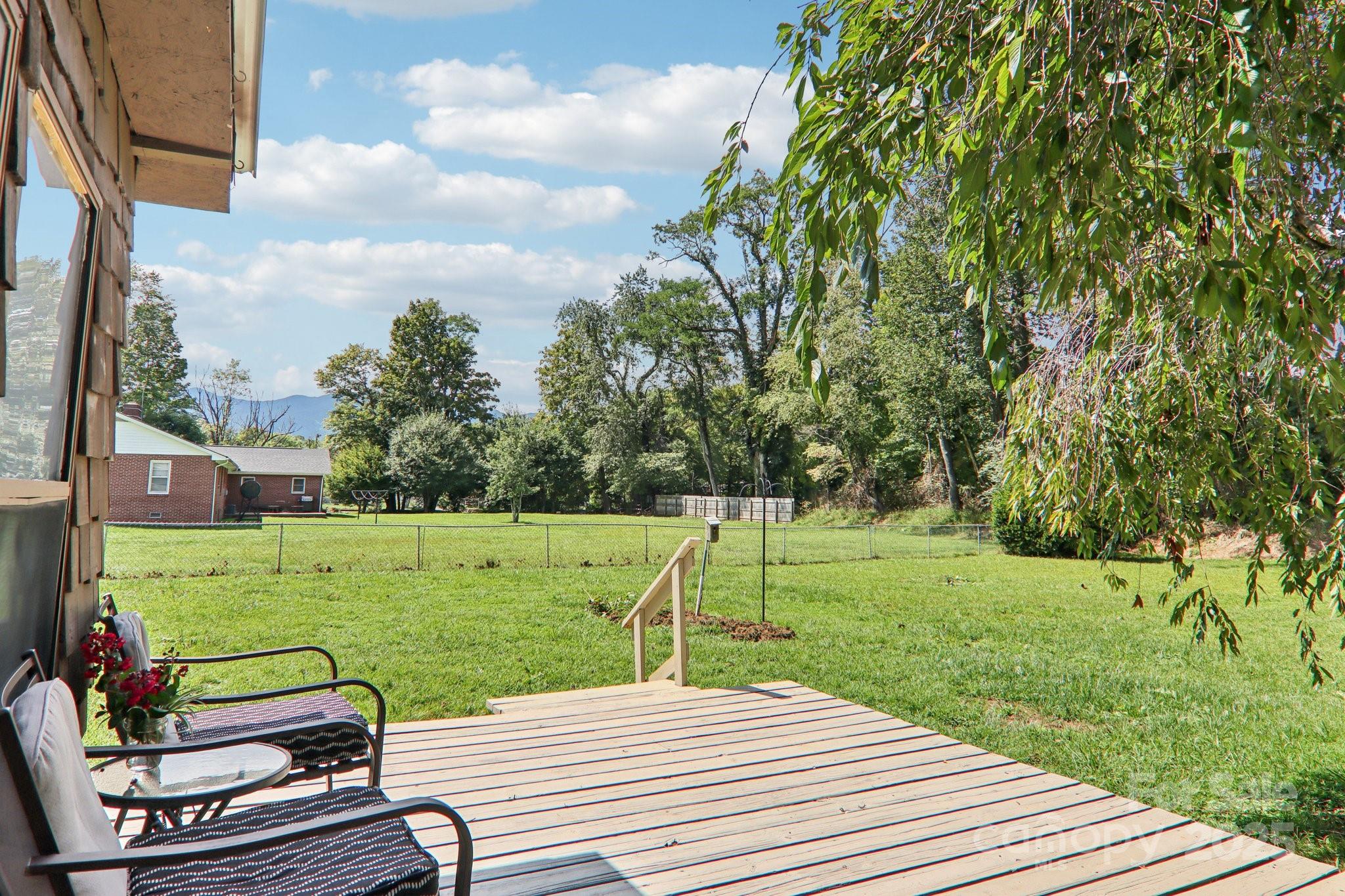 55 Polk Street Waynesville, NC 28786 - Photo 31 of 44 a view of a deck with wooden floor and a yard