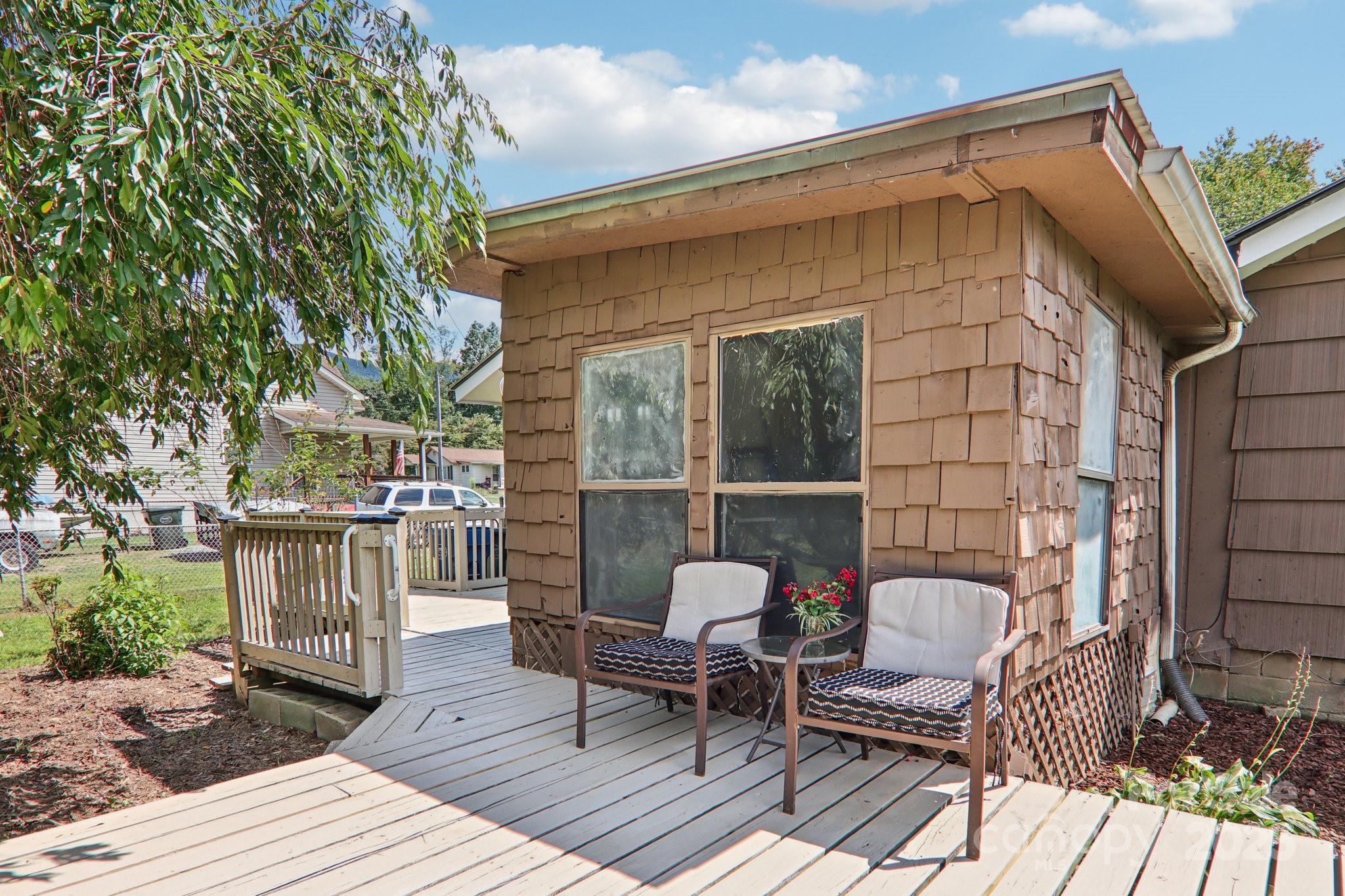 55 Polk Street Waynesville, NC 28786 - Photo 39 of 44 a roof deck with a table and chairs and potted plants