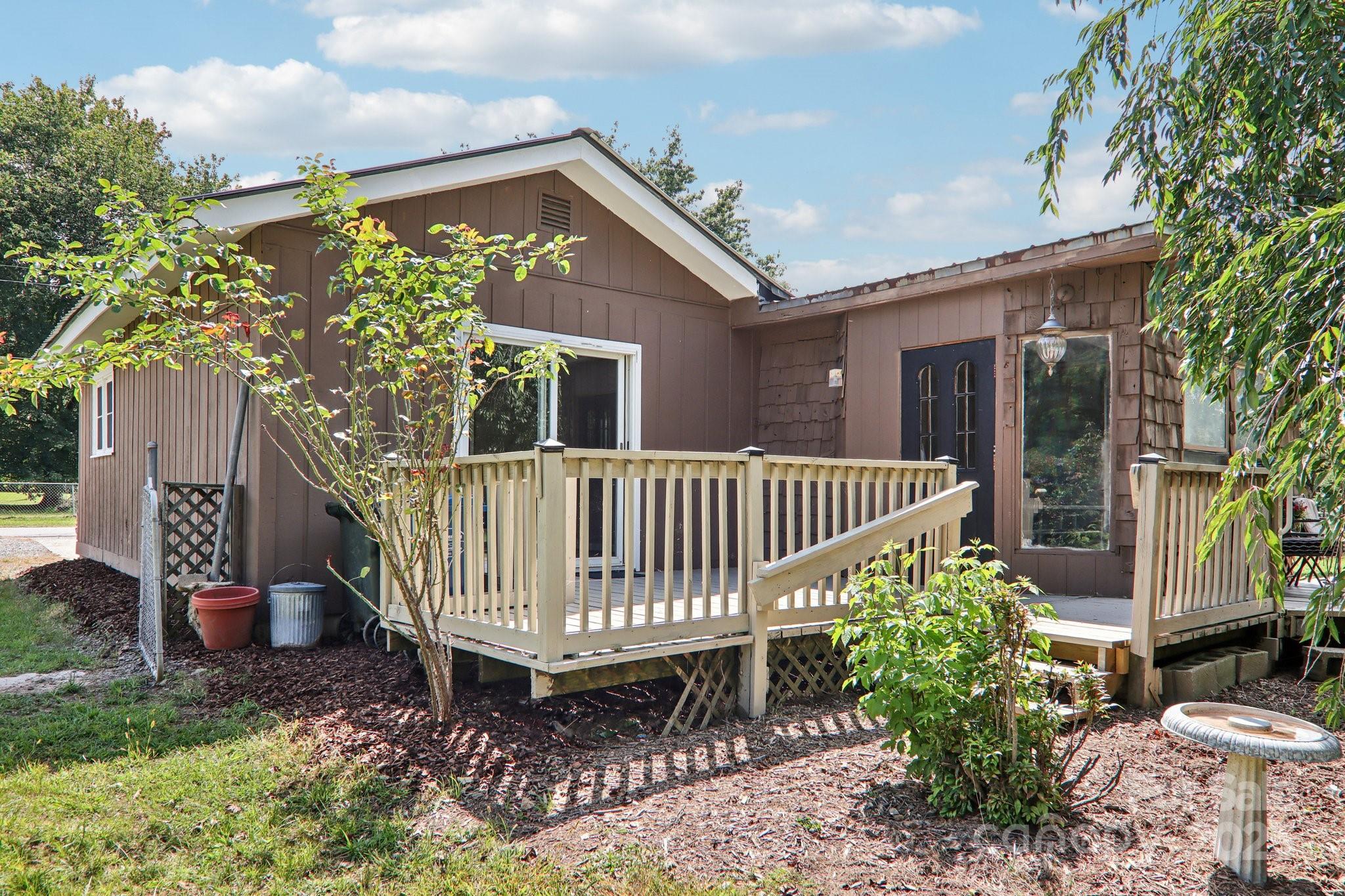 55 Polk Street Waynesville, NC 28786 - Photo 42 of 44 a view of a house with a wooden deck and a yard