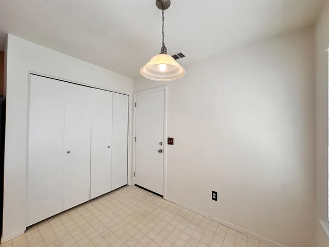 a view of an empty room with a chandelier fan