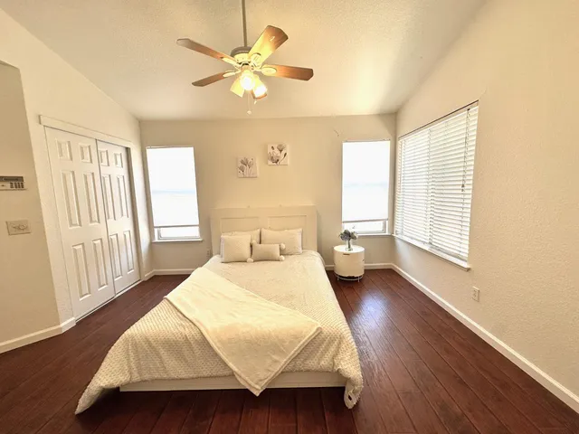a bedroom with a bed mirror and a window