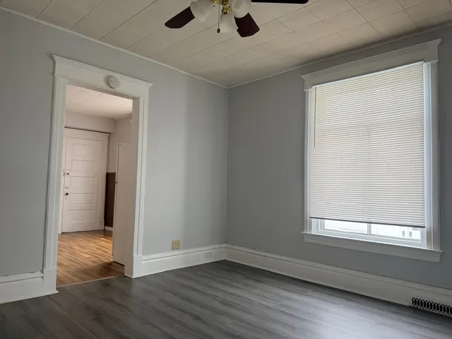 an empty room with wooden floor and a window