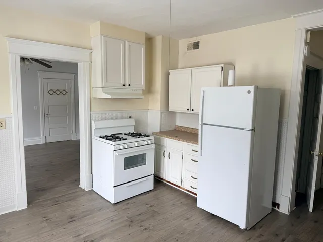 a kitchen with cabinets and white stainless steel appliances