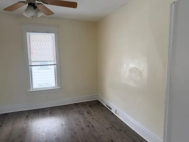 an empty room with a window and a fan