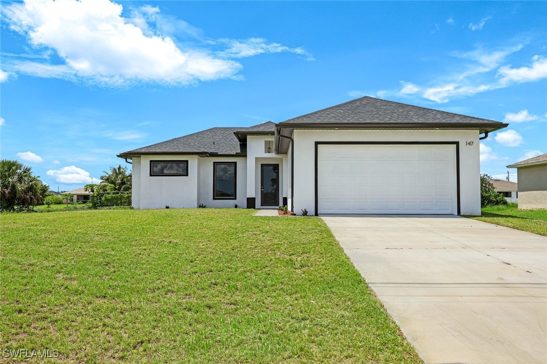 147 Partridge Street Lehigh Acres, FL 33974 - Photo 1 of 20 a front view of a house with a yard and garage