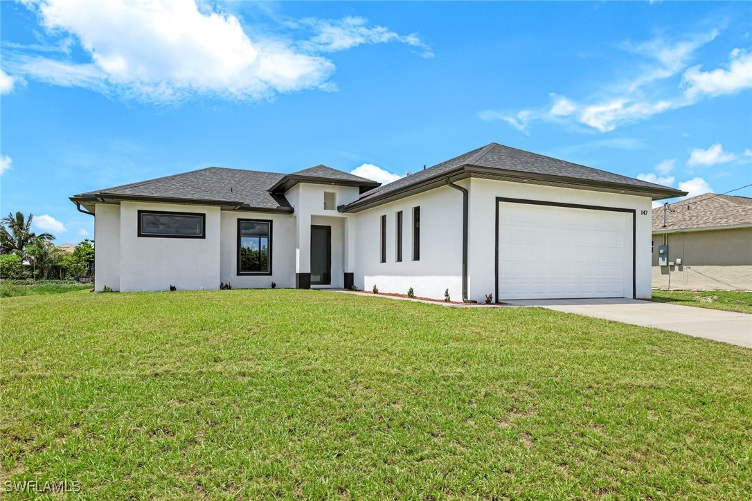 147 Partridge Street Lehigh Acres, FL 33974 - Photo 2 of 20 a front view of a house with a garden