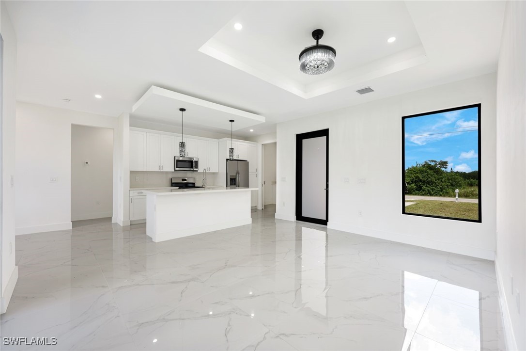 147 Partridge Street Lehigh Acres, FL 33974 - Photo 5 of 20 a large kitchen with stainless steel appliances kitchen island granite countertop a refrigerator and a sink