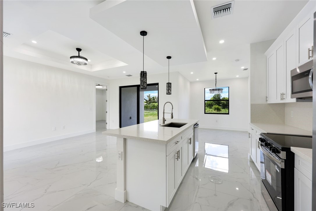 147 Partridge Street Lehigh Acres, FL 33974 - Photo 8 of 20 a kitchen with stainless steel appliances granite countertop a sink and a stove