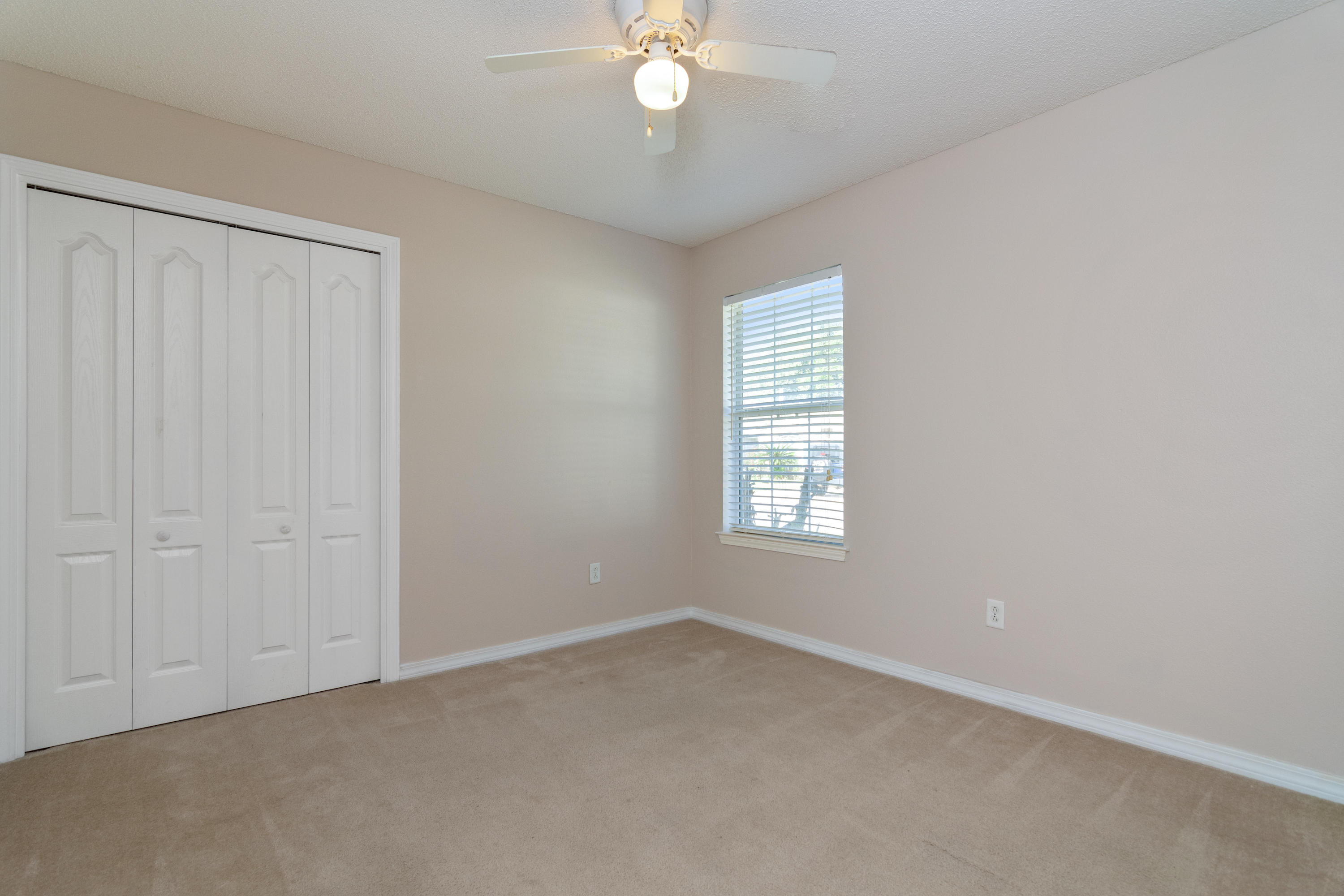 1845 Brick Circle Fort Walton Beach, FL 32547 - Photo 19 of 24 an empty room with a chandelier fan and windows