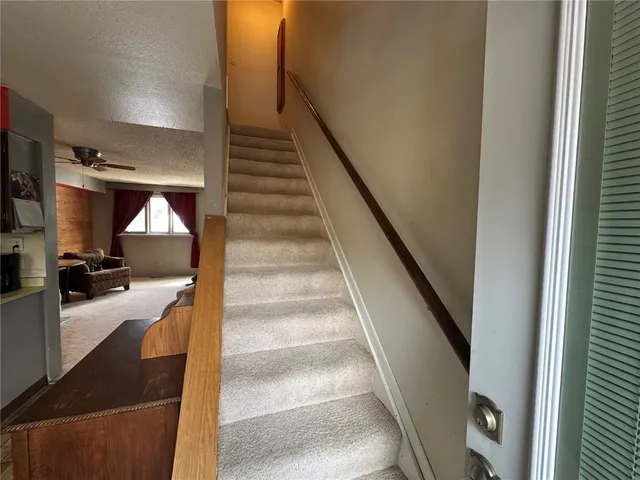 a view of staircase and living room with wooden floor