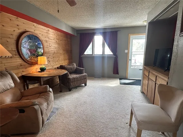 a living room with furniture a window and a flat screen tv
