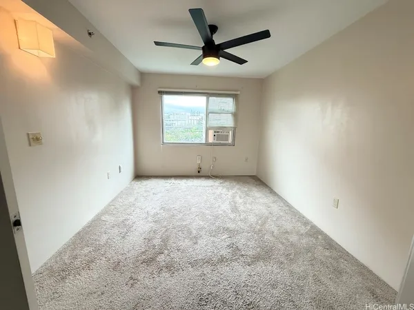 an empty room with a ceiling fan and window