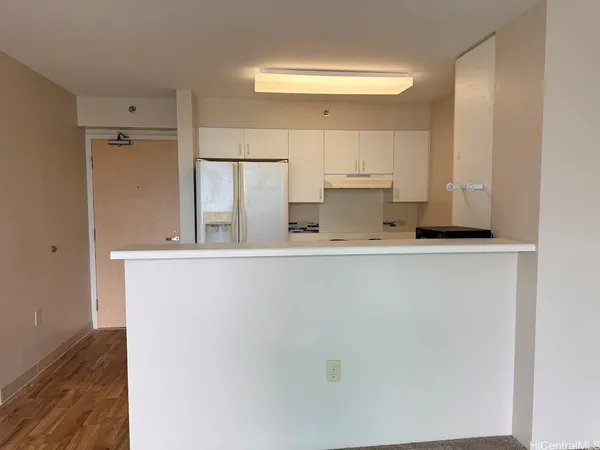 a kitchen with a refrigerator and white cabinets