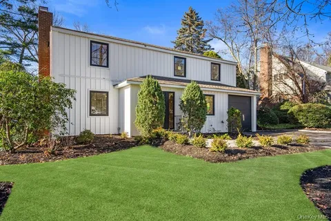a front view of a house with a garden and plants