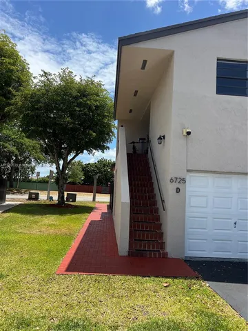 a view of swimming pool with lawn chairs and plants