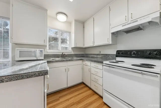 a kitchen with granite countertop cabinets sink and window