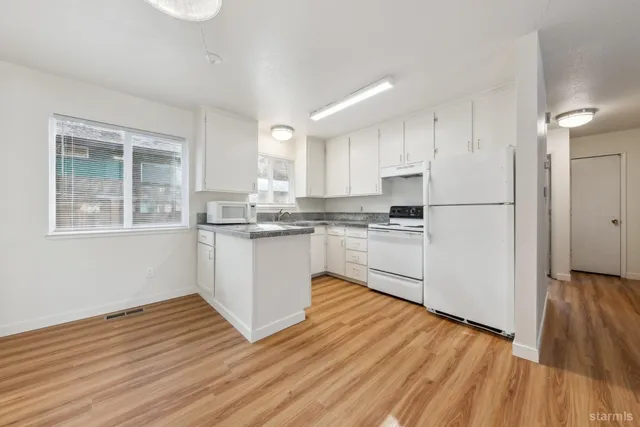 a kitchen with granite countertop a stove a sink and a microwave
