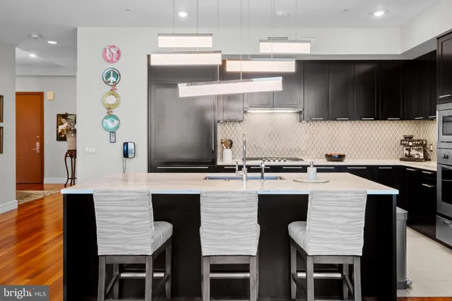 a kitchen with stainless steel appliances a sink stove and refrigerator