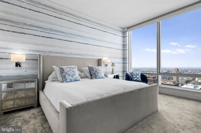 a bedroom with a bed and view of living room