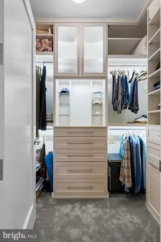 a view of walk in closet with clothes and shoes