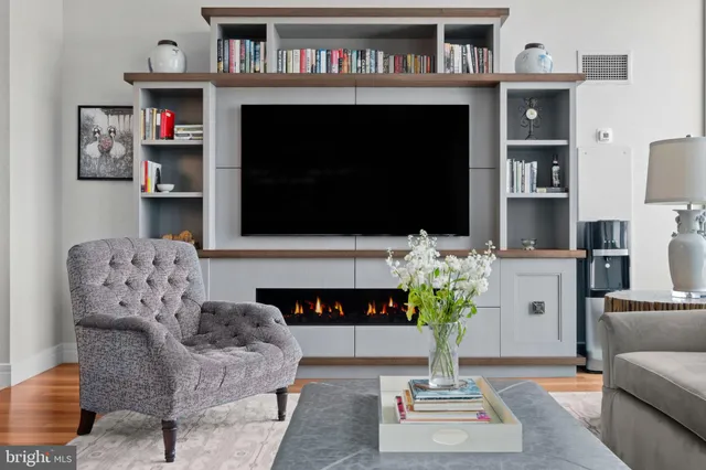 a living room with furniture a flat screen tv and a fireplace