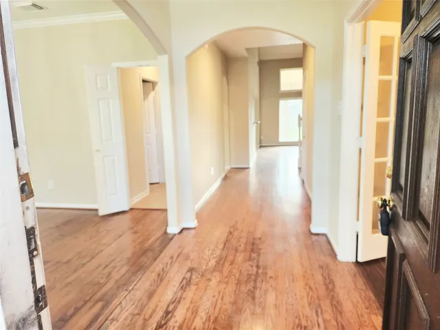 a view of a hallway with wooden floor and staircase