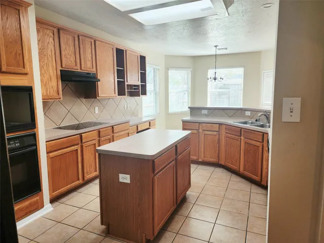 a kitchen with a stove sink and cabinets