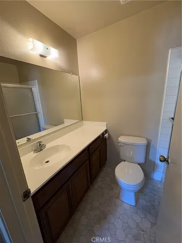 a bathroom with a sink a toilet a mirror and vanity