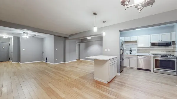 a kitchen with stainless steel appliances granite countertop a sink a stove and a refrigerator