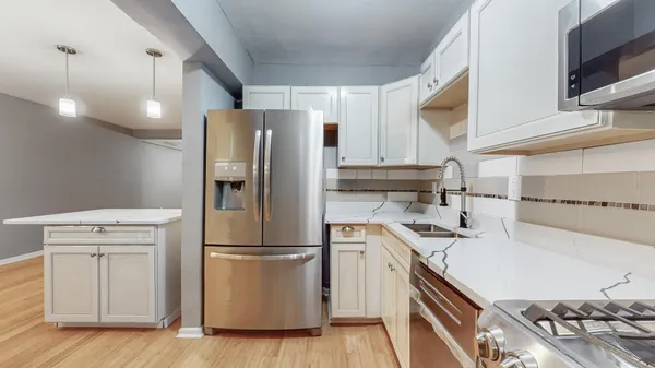 a kitchen with a sink a refrigerator and a stove top oven