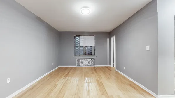 a view of a room with wooden floor and cabinets