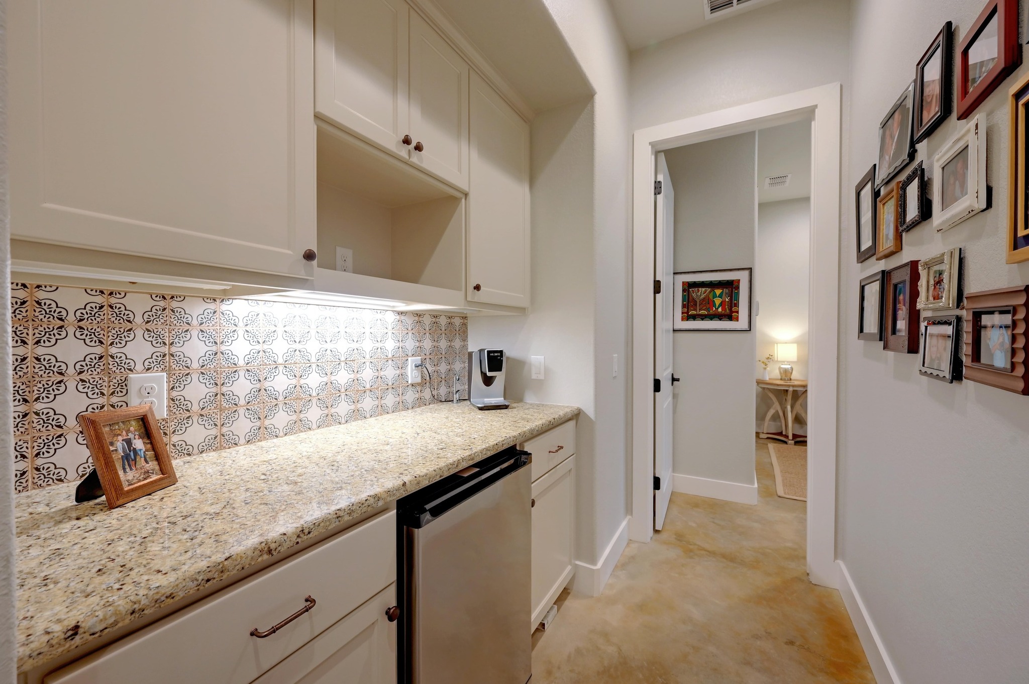 401 Trail Ridge Road Wimberley, TX 78676 - Photo 25 of 34 Kitchen featuring stainless steel fridge, tasteful backsplash, light stone counters, and white cabinets