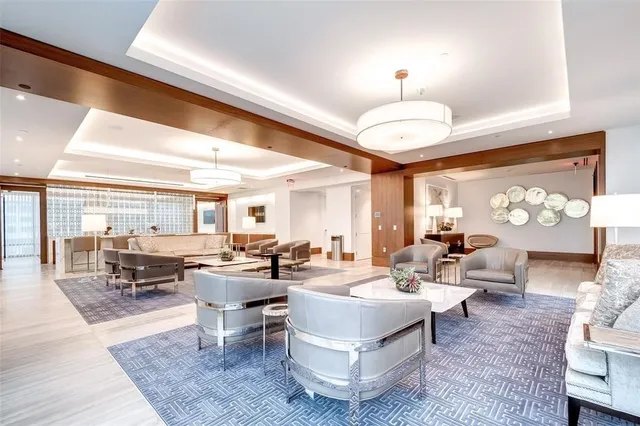 a living room with furniture a chandelier and a large window