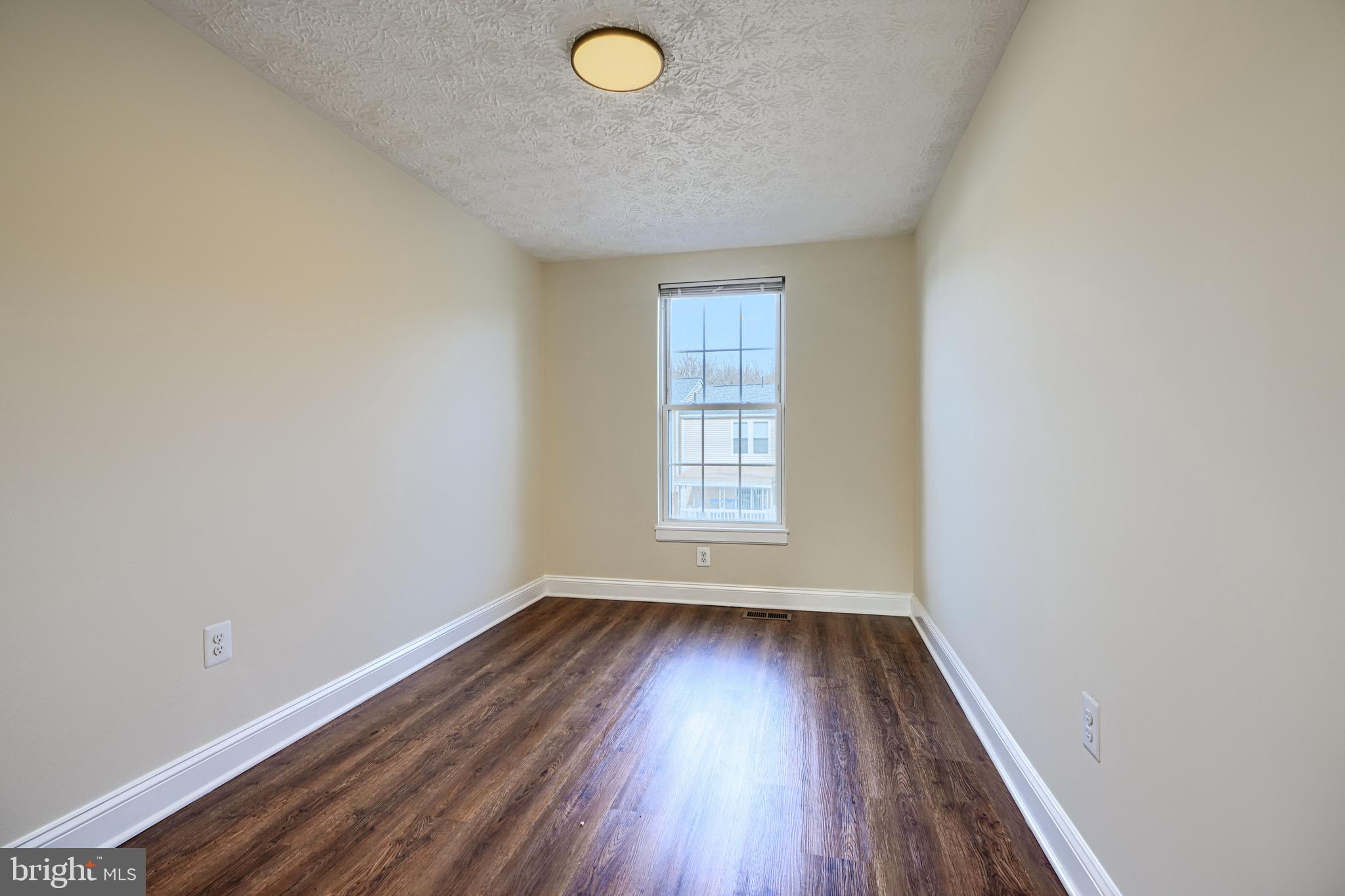 3944 Cutty Sark Road Baltimore, MD 21220 - Photo 15 of 27 an empty room with wooden floor and windows