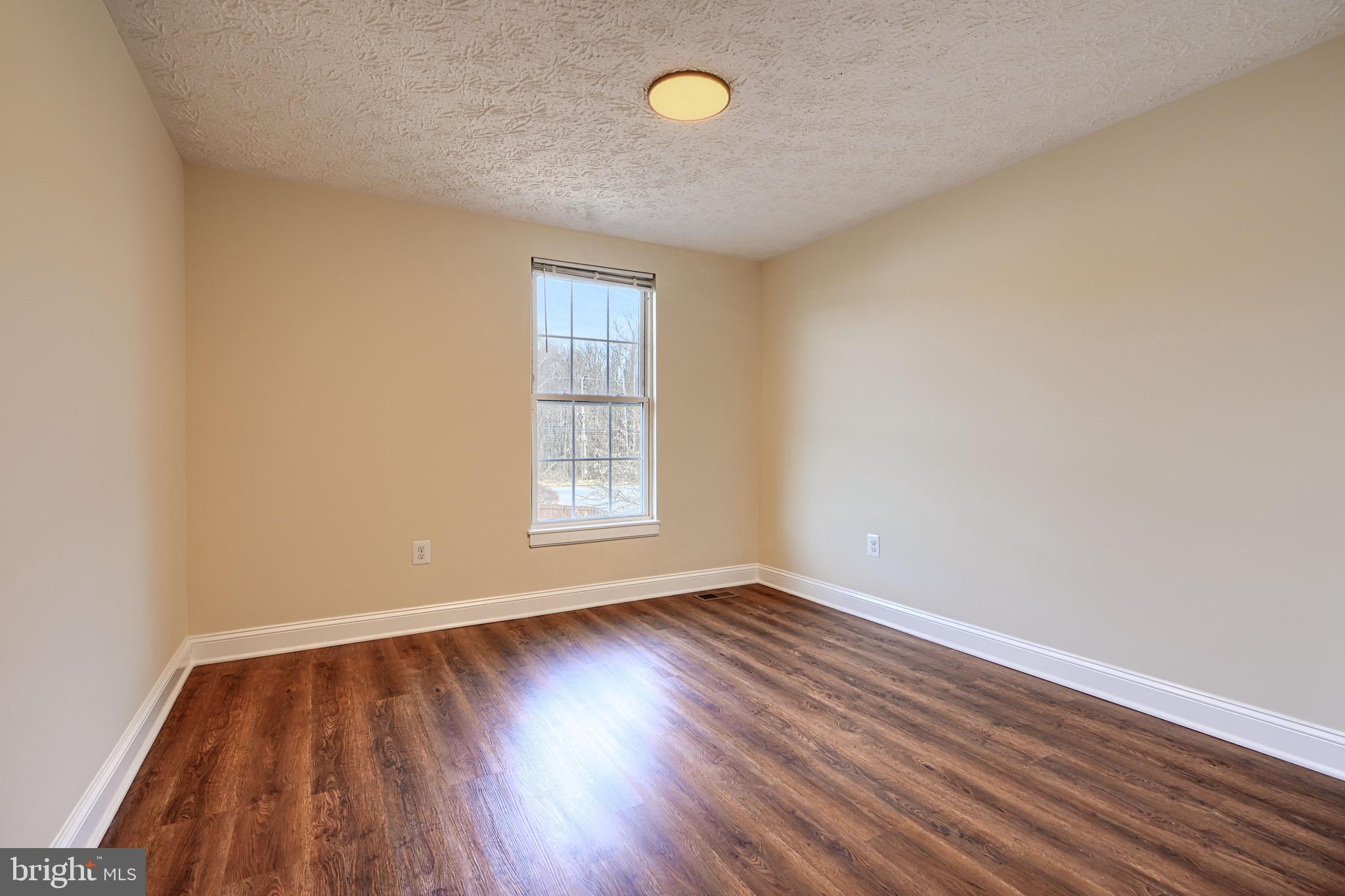 3944 Cutty Sark Road Baltimore, MD 21220 - Photo 17 of 27 an empty room with wooden floor and windows