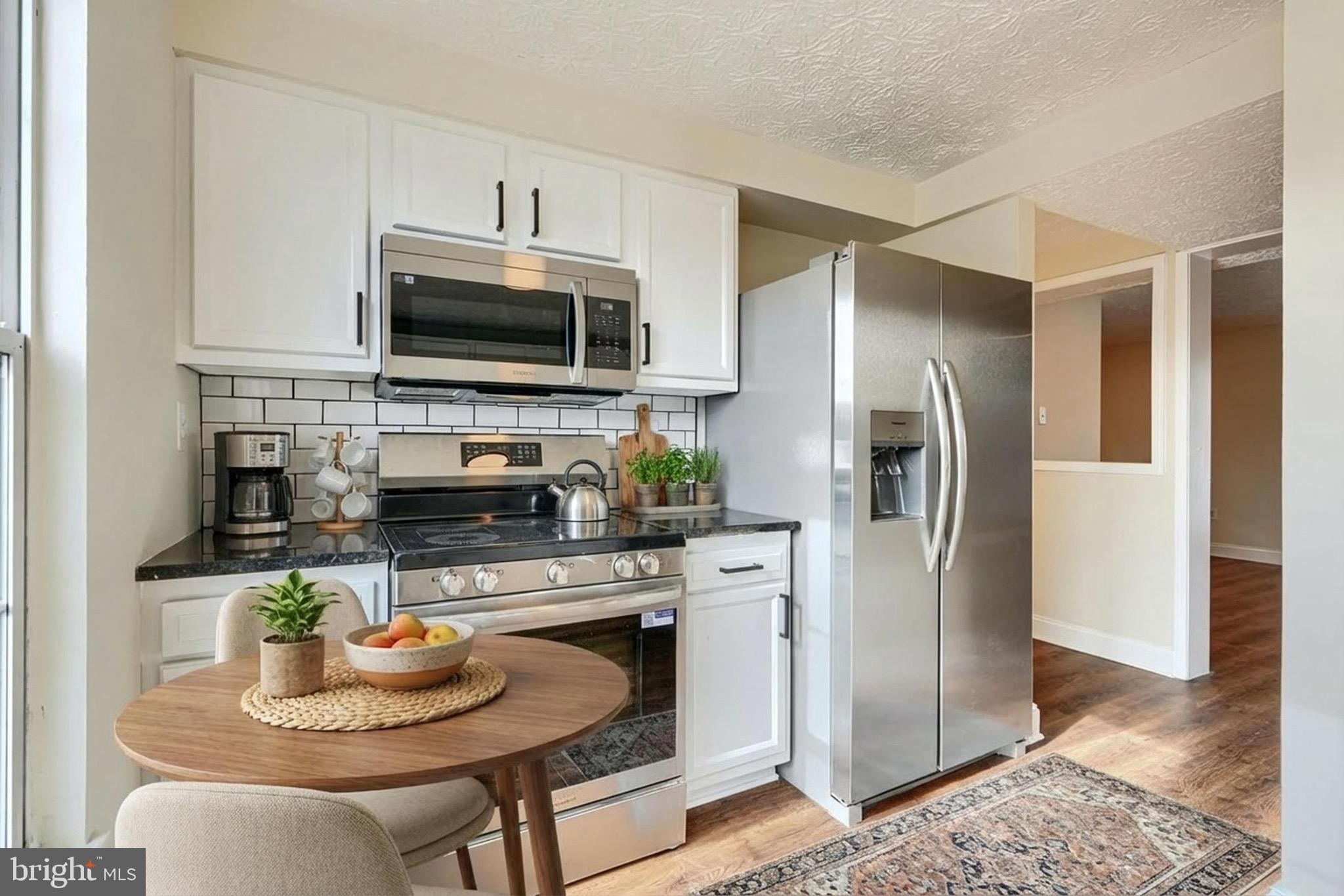 3944 Cutty Sark Road Baltimore, MD 21220 - Photo 6 of 27 a kitchen with stainless steel appliances granite countertop a refrigerator a stove a microwave and a refrigerator