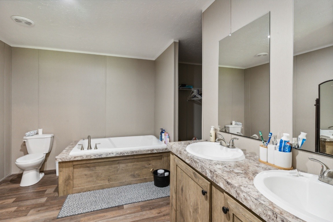 235 Antioch Road Lafayette, TN 37083 - Photo 16 of 17 a bathroom with a granite countertop sink a large mirror and toilet