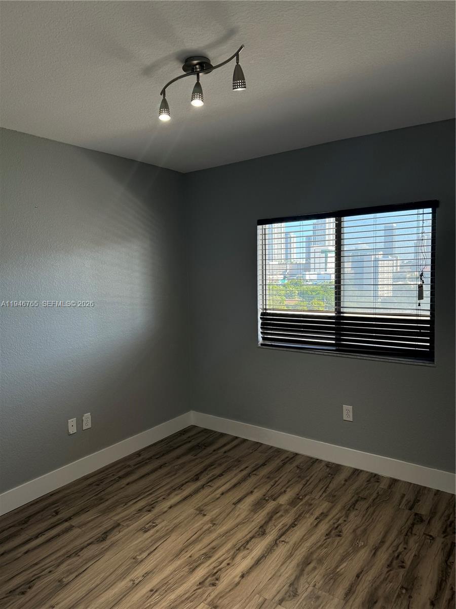 36 Northwest 6th Avenue, Unit 1106 Miami, FL 33128 - Photo 15 of 34 a view of an empty room with wooden floor and a window