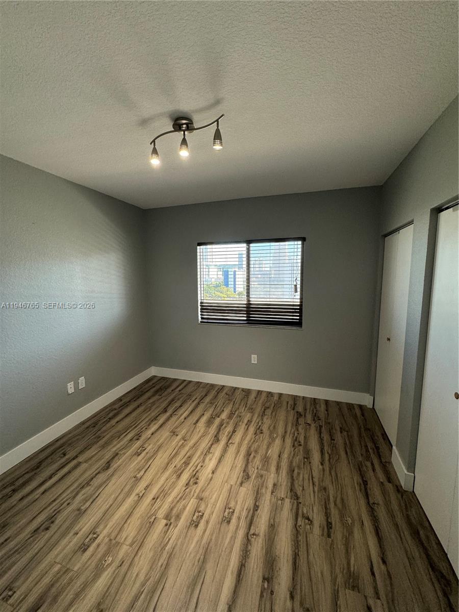 36 Northwest 6th Avenue, Unit 1106 Miami, FL 33128 - Photo 16 of 34 an empty room with wooden floor and windows