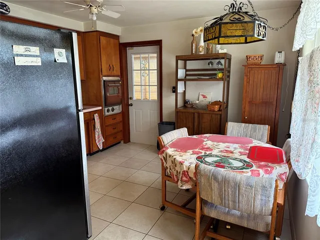 a kitchen with stainless steel appliances a stove a refrigerator wooden floor and dining table