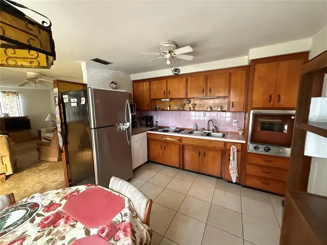 a kitchen with a refrigerator and a stove top oven