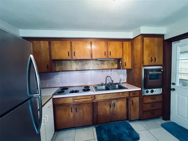 a kitchen with kitchen island granite countertop a sink stove and cabinets