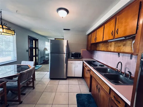 a kitchen with a sink a refrigerator and cabinets