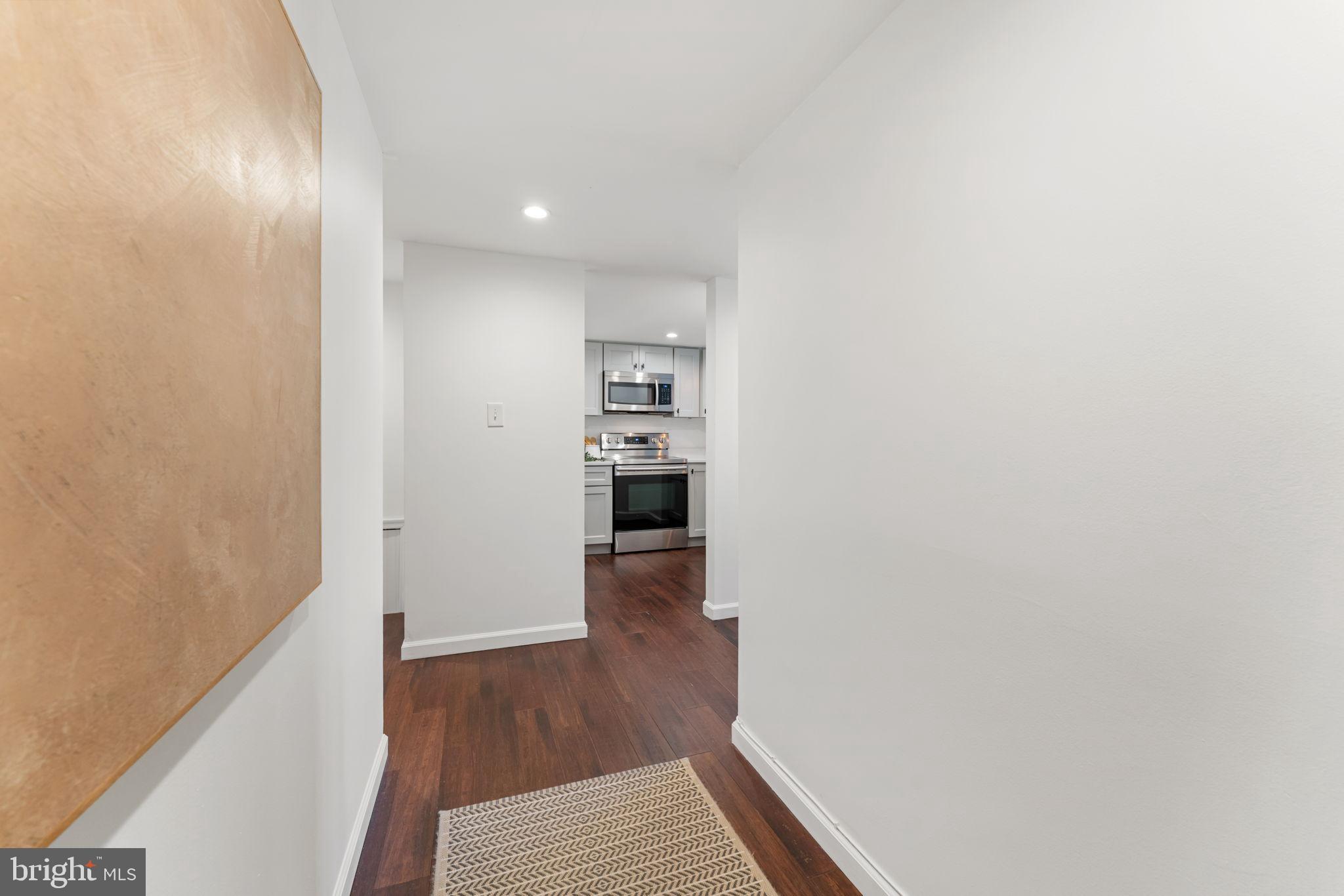 1700 17th Street Northwest, Unit 508 Washington, DC 20009 - Photo 2 of 24 a view of a hallway with wooden floor and a kitchen