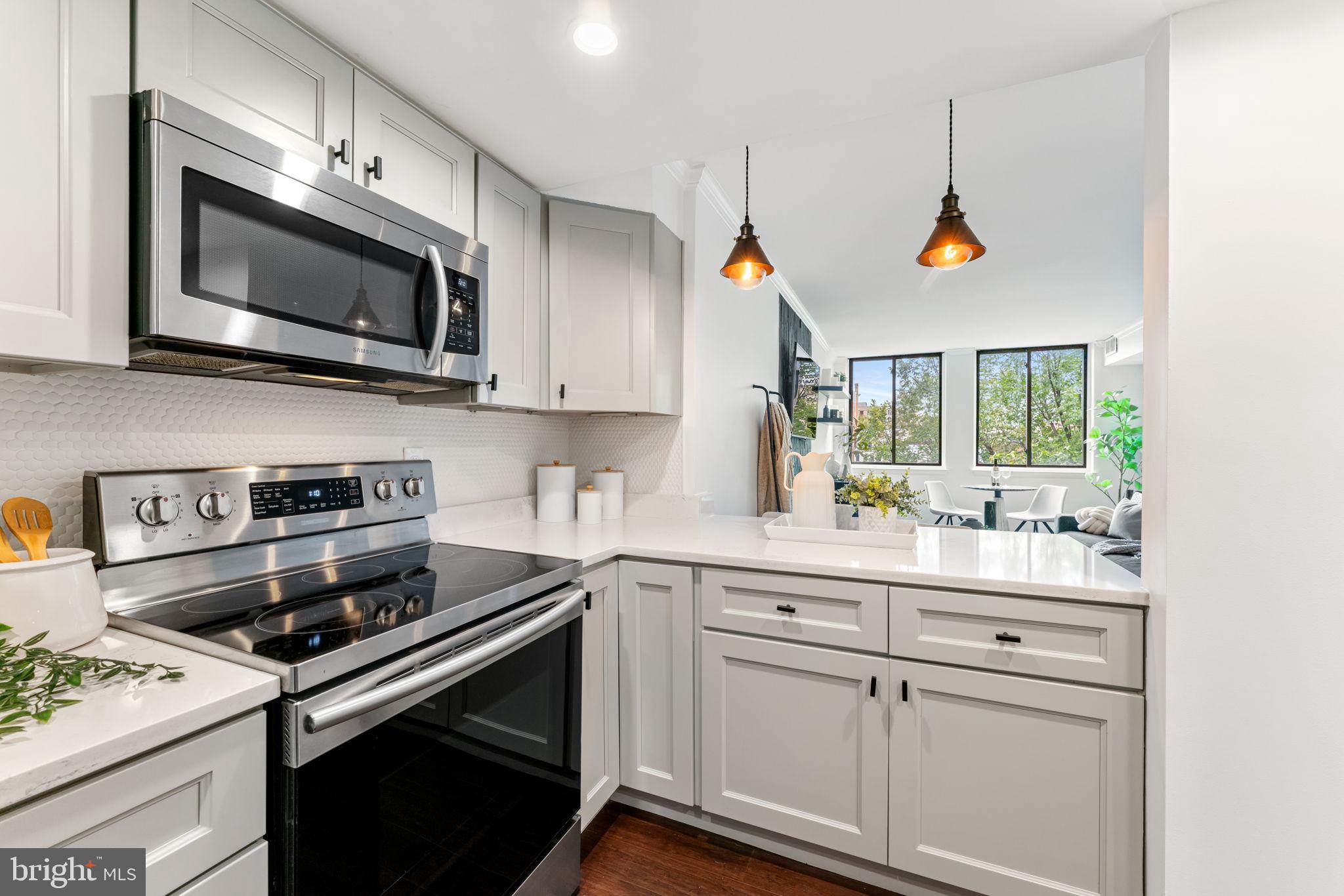 1700 17th Street Northwest, Unit 508 Washington, DC 20009 - Photo 4 of 24 a kitchen with stainless steel appliances white cabinets and a stove