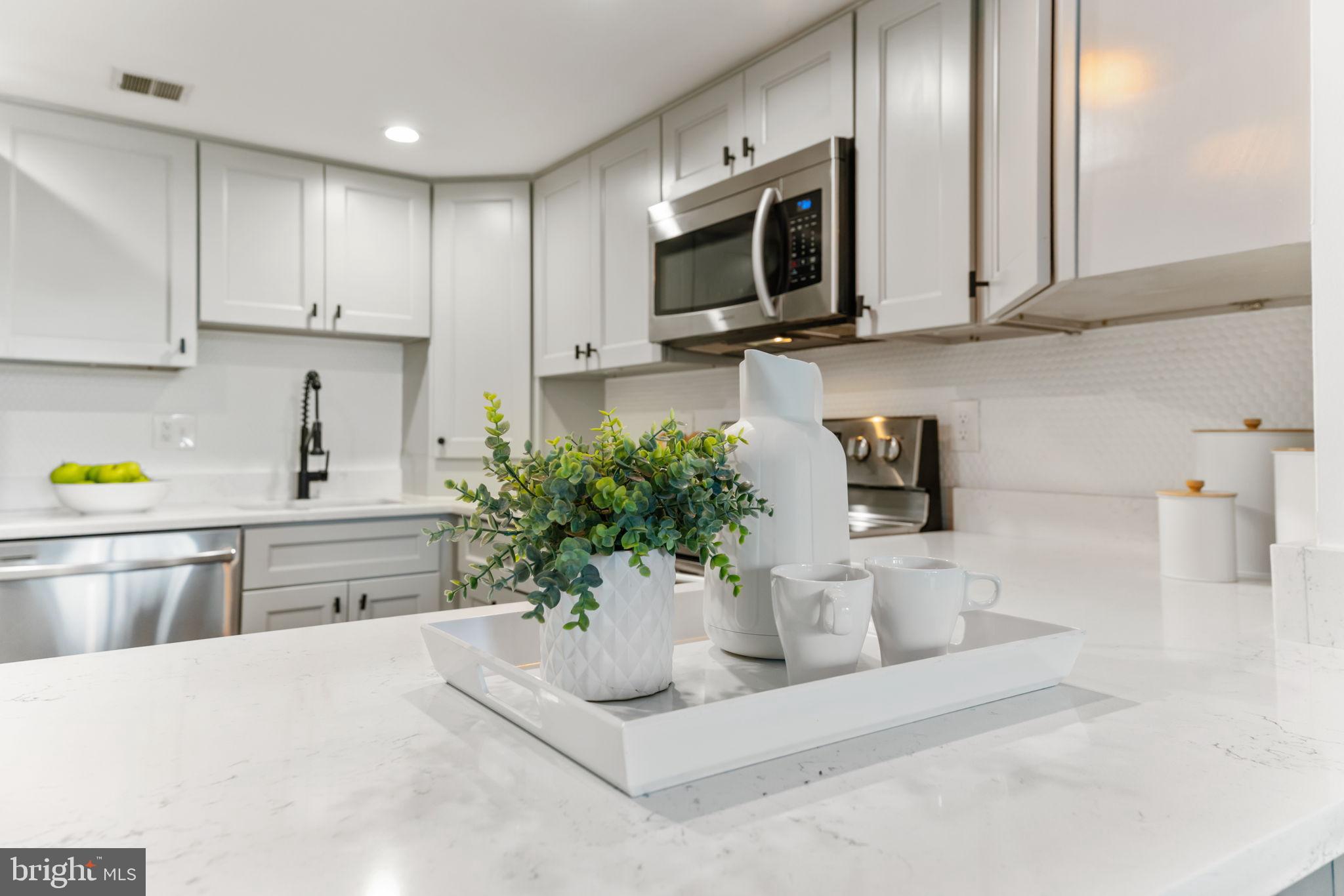 1700 17th Street Northwest, Unit 508 Washington, DC 20009 - Photo 6 of 24 a kitchen with stainless steel appliances a microwave sink refrigerator and cabinets