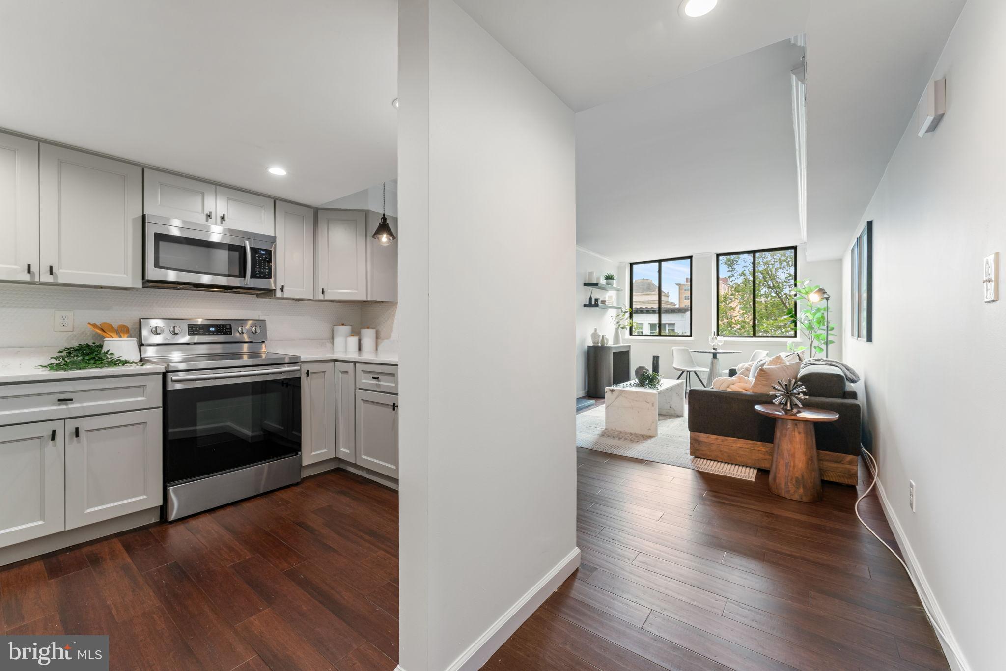 1700 17th Street Northwest, Unit 508 Washington, DC 20009 - Photo 7 of 24 a kitchen with kitchen island white cabinets and stainless steel appliances