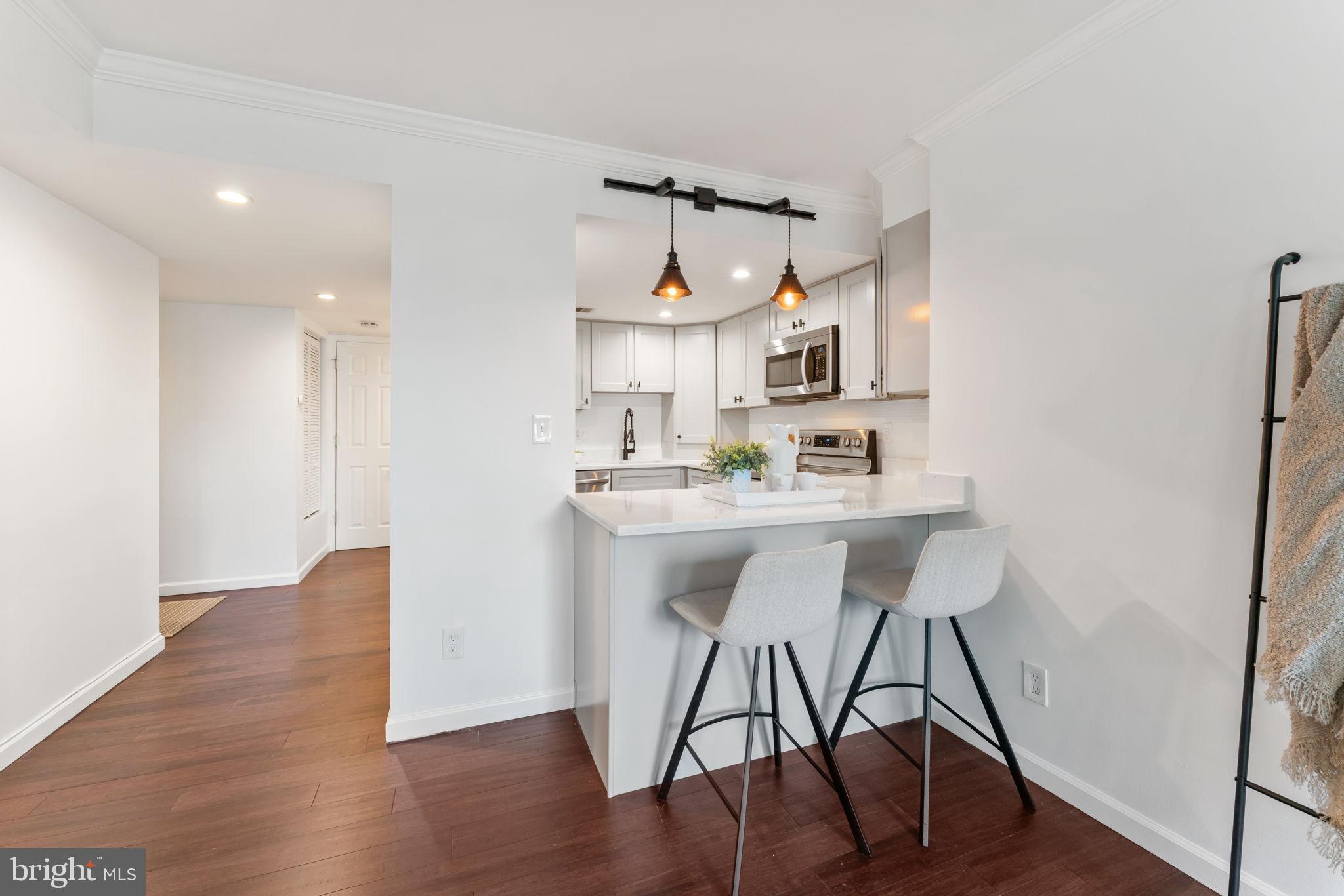 1700 17th Street Northwest, Unit 508 Washington, DC 20009 - Photo 8 of 24 a kitchen with stainless steel appliances a dining table chairs and wooden floor
