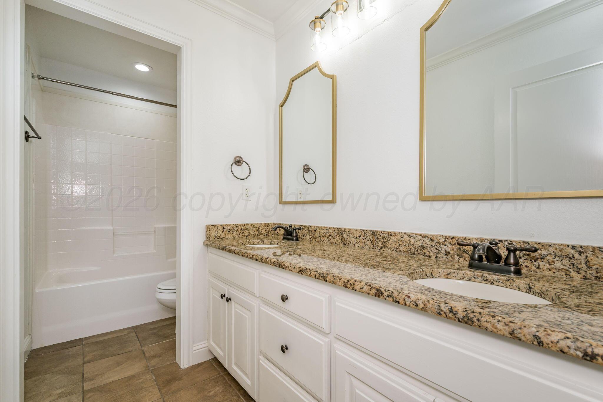 16700 Dove Meadow Road Canyon, TX 79015 - Photo 14 of 24 a bathroom with a granite countertop sink mirror and a bathtub